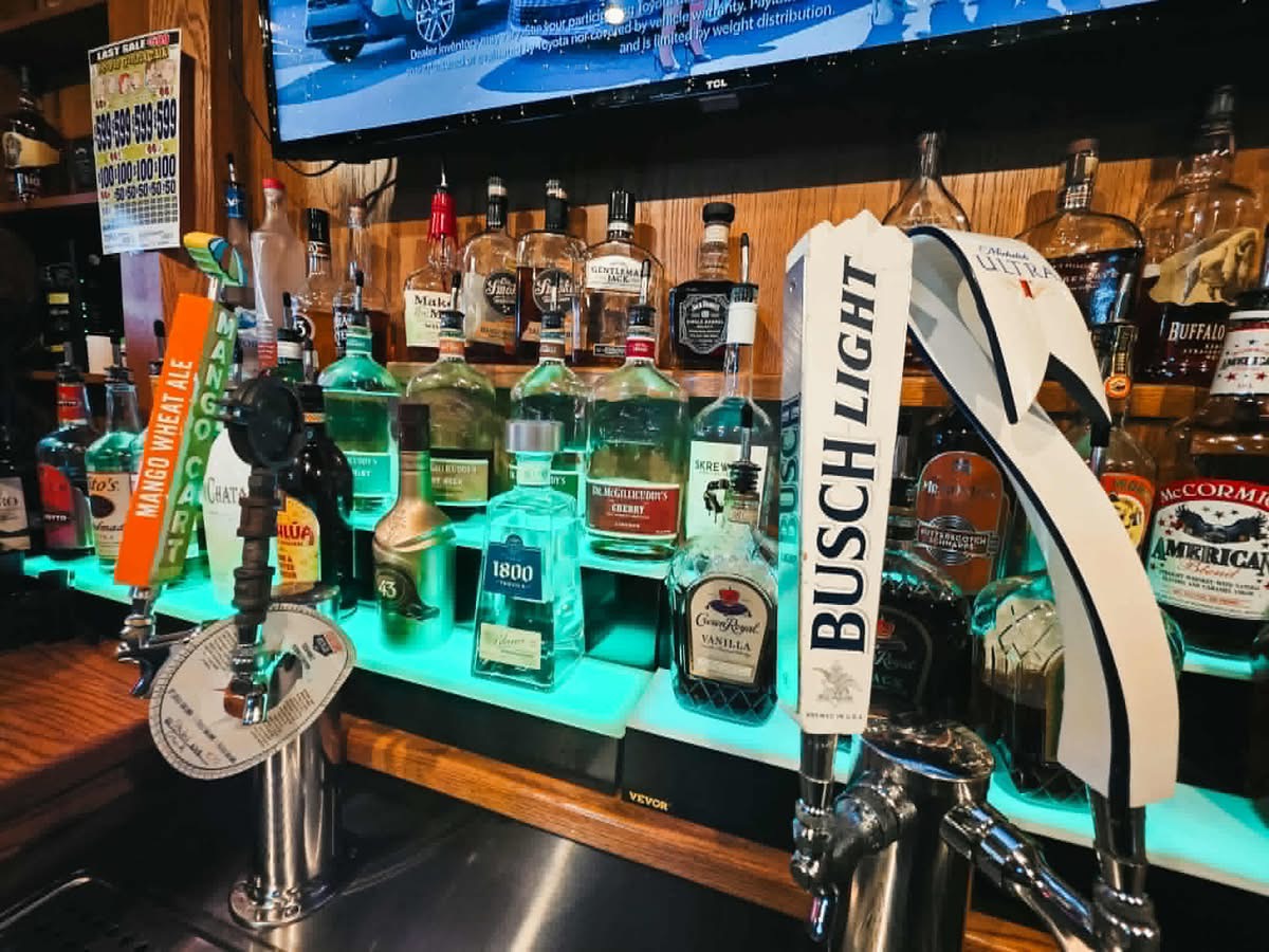 The Vault bar taps and full spirit shelf — Busch Light draft, Mango Cart, and liquor selection