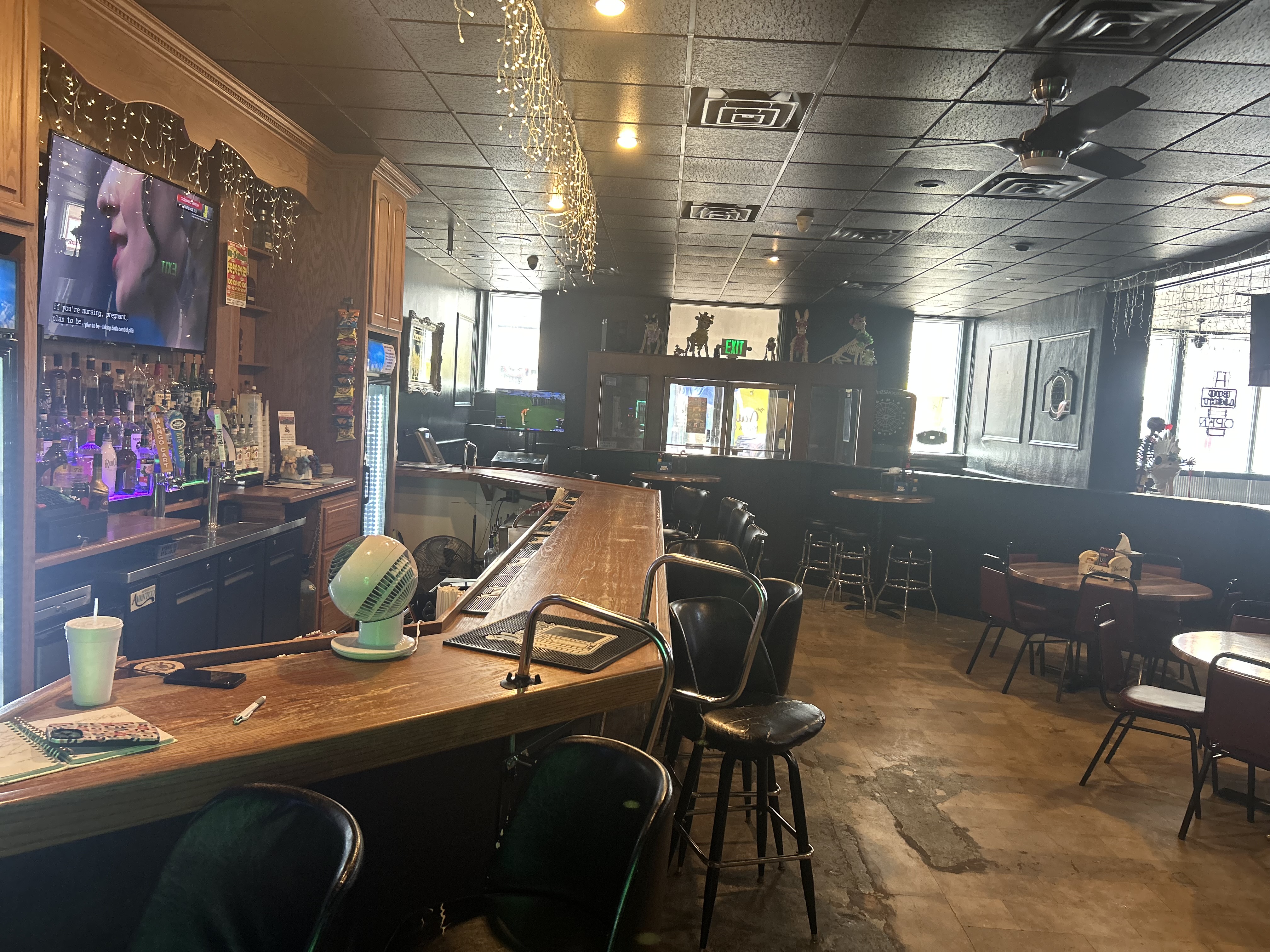 The Vault bar counter — bar top, stools, TVs, natural window light