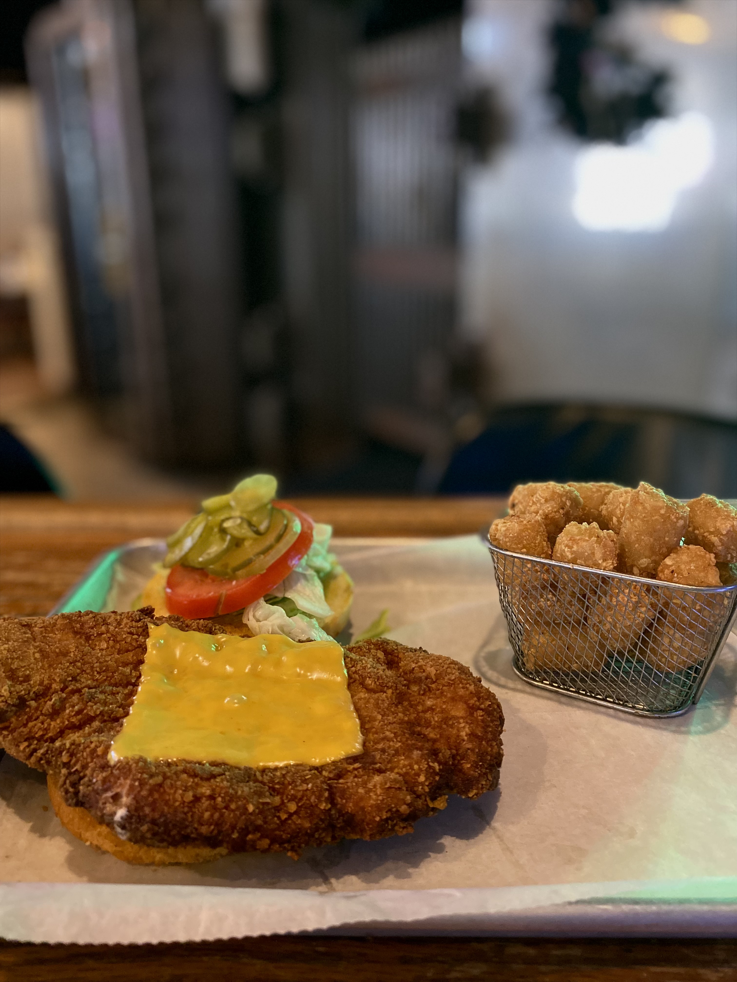 Breaded pork tenderloin sandwich with cheese and tots
