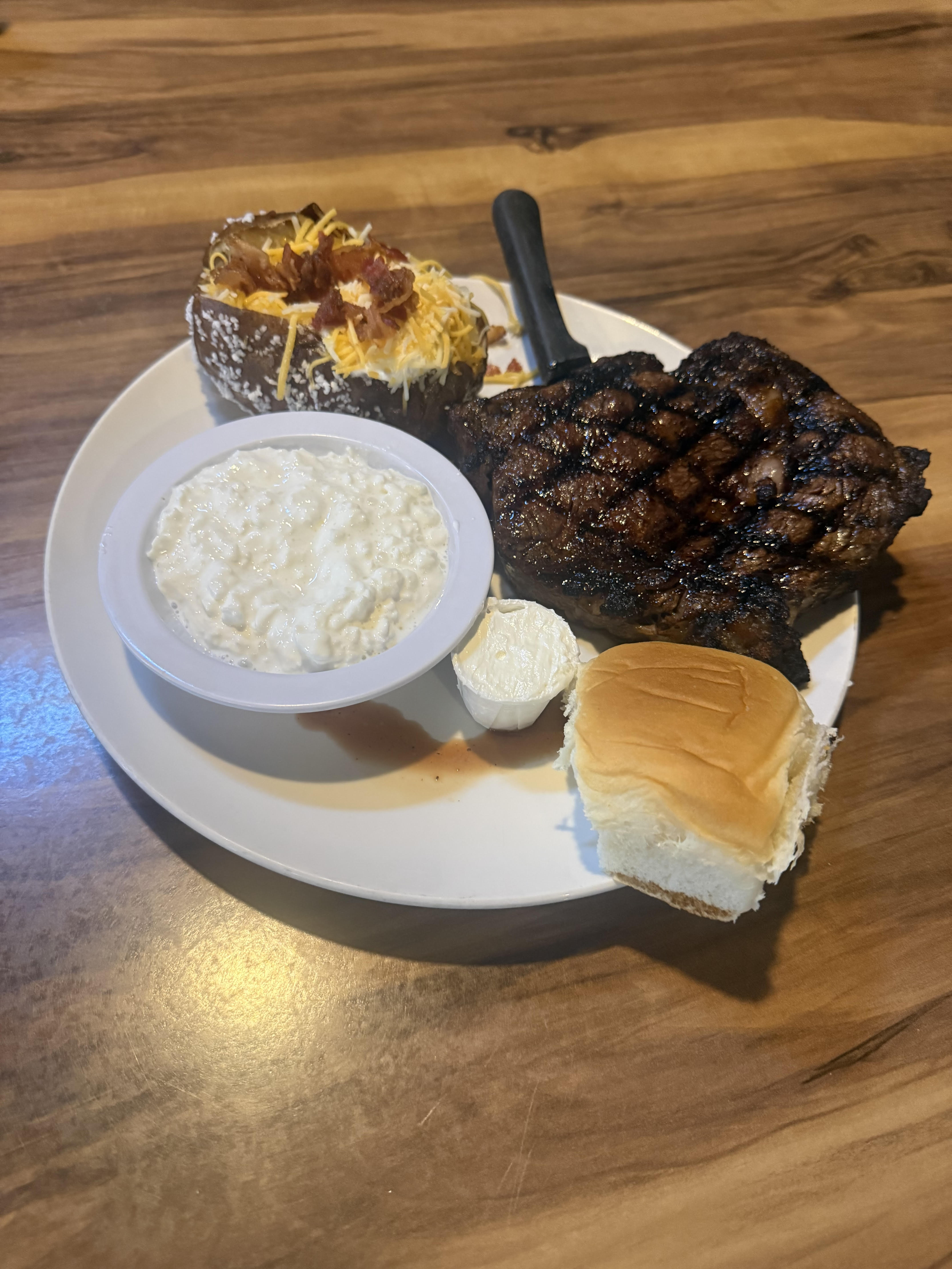 Ribeye steak with loaded baked potato and cottage cheese
